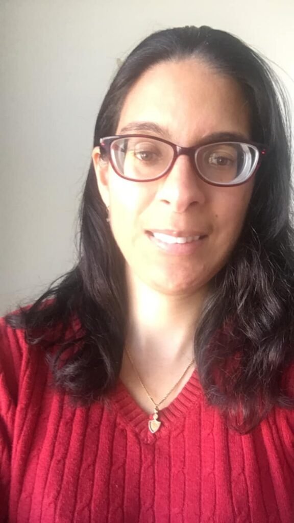 Woman with glasses and black hair wearing a red sweater for Go Red For Women Heart Health Awareness