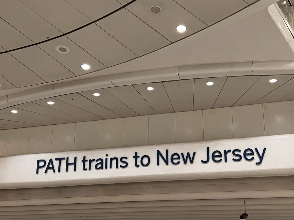 sign pointing to trains from New York to New Jersey