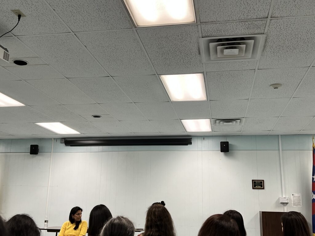 library meeting room where teens can volunteer. Woman with yellow top facing audience.
